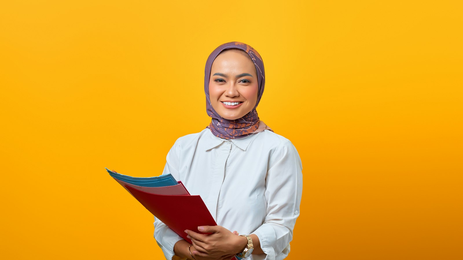 Pelamar magang berhijab tersenyum memegang map berkas lamaran