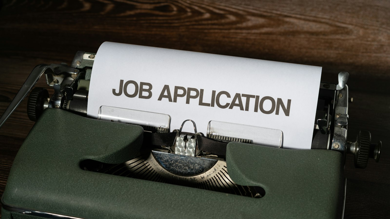 Mesin tik dengan kertas bertuliskan Job Application